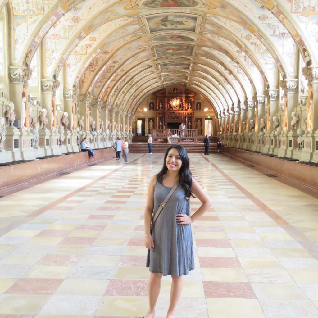 Natalie Torres full body picture showing her standing inside of the Munich Residenz in Germany.
