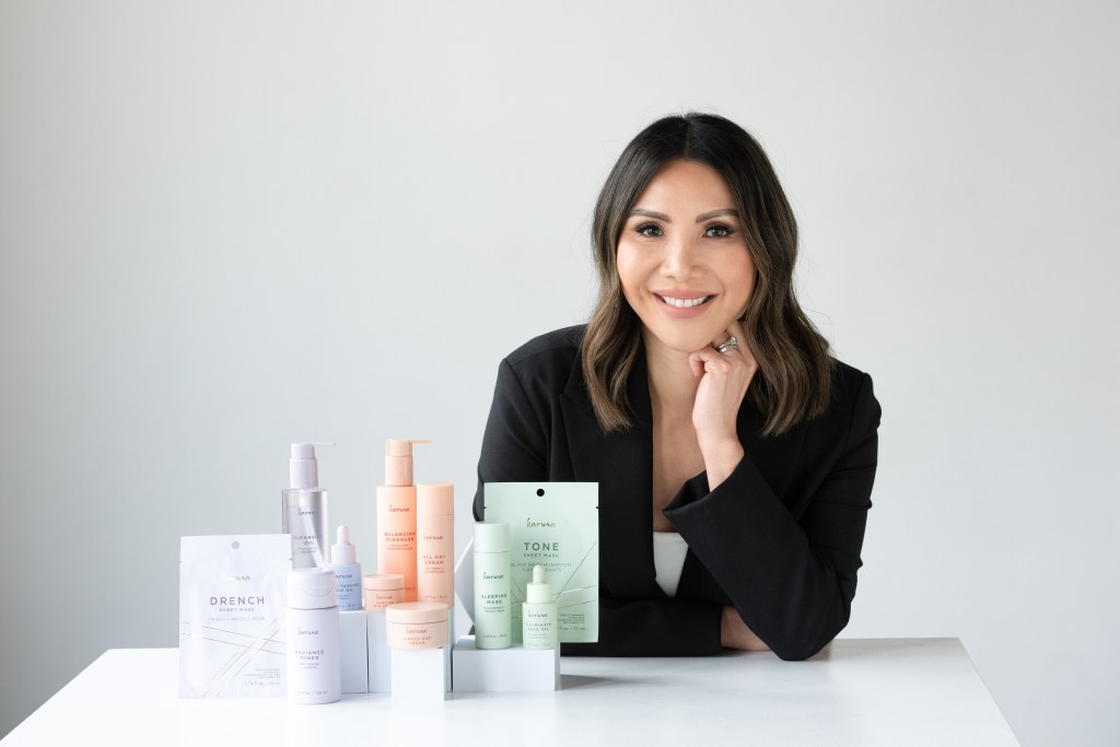 In the photo we see Linda Wang, the CEO & Founder of Karuna Skin. She is standing alongside the Balancing Collection. 